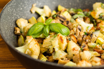 Vegetable mix with fried mushrooms in a frying pan