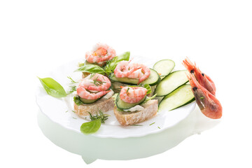 Small canapes with shrimps, salad and cucumbers on a white background