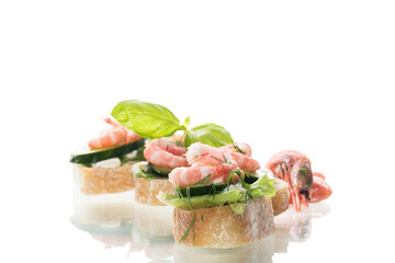Portioned appetizers with shrimps, salad leaves and sauce isolated