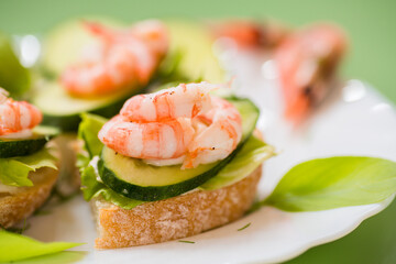 Portioned appetizers with shrimps, lettuce and sauce isolated on a green background