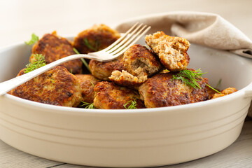 Delicious fried cutlets in a baking dish on a white table