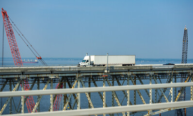 Truck driving across the bridge. Lorry transporting. Cargo trailer. Logistics truck, international shipment. Truck transport. Semi truck containers, logistics industry. Trucks lorry logistic concept.