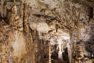 A close-up view of intricate stalactites and stalagmites forming natural brown and white rock formations inside a cave, showcasing geological beauty and natural wonders, concept of geology, cave