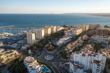 Obraz premium Aerial view of a large urban park in Estepona, surrounded by residential buildings and overlooking the Mediterranean Sea and marina.