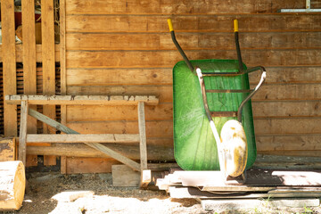 Old wooden shed with green wheelbarrow