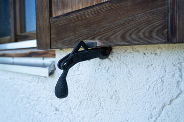 Metal shutter latch on country house window shutter 