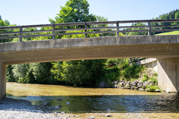Concrete bridge over clear river water in landscape