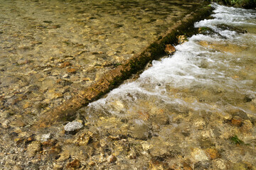 Clear river water flowing over rocks and stones