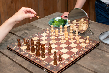Chessboard with chess pieces reflected in a mirrors	