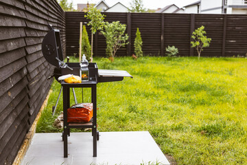 A barbecue grill is set up in a backyard, ready for a summer cookout. A BBQ grill sits ready for...