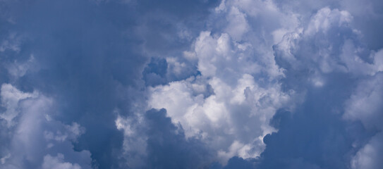 Blue sky with fluffy clouds background. Bright blue sky background. Cloudscape with white clouds. Calm sky on a sunny day. Sunlight through the clouds wallpaper. Spring sky with soft clouds.