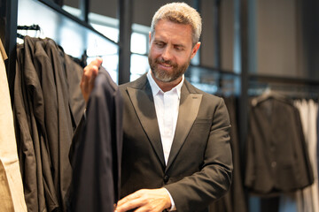 A boutique consultant helps a customer find the perfect suit. A luxury store collection of premium...