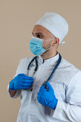 Portrait of caucasian professional doctor in protective cloth mask and gloves stethoscope isolated