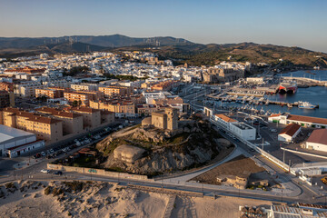 An aerial view of Tarifa's whitewashed buildings and ancient fortress, nestled between the sea and...