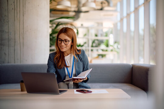 Happy businesswoman using laptop while working in the office.