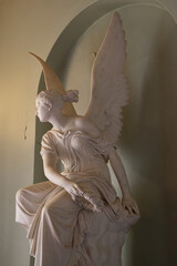 An isolated statue of an angel sitting on a column, Osborne House royal palace, Isle of Wight.