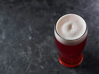 Red beer glass on concrete table with copy space