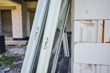 New windows in frames, ready to be installed on house at a construction side