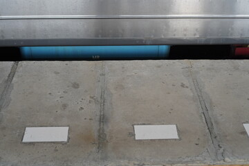 Concrete Surface with Blue Pipe and Metallic Structure, Industrial Aesthetic.