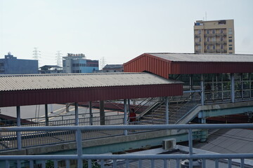 Elevated Pedestrian Walkway Over Cityscape with Red Roof
