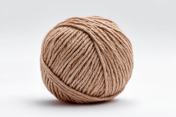 A tancolored yarn ball is against a white backdrop