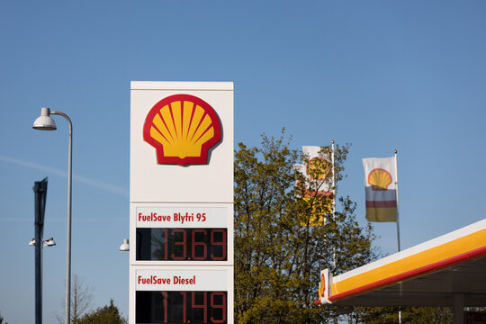 Denmark, Copenhagen, May 12, 2023 - Shell Price pylon and flags on blue skies bagground