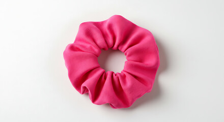 A bright pink fabric scrunchie, a popular retro hair accessory, isolated on a clean white background. A simple, vibrant fashion object for style concepts.
