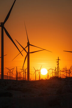 Palm Springs Windmills at Coachella Valley, California, USA at sunset against orange sky