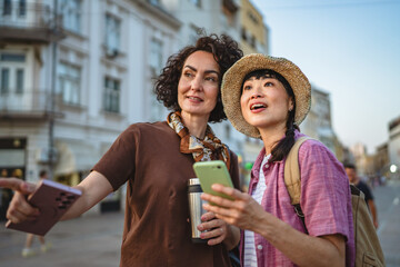 two women use mobile phone walk and touring city on vacation