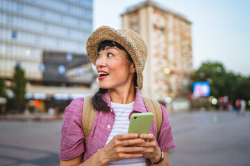 japanese woman use mobile phone walk with suitcase and touring city