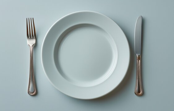 Highlighting food insecurity with an empty plate and utensils on a neutral background