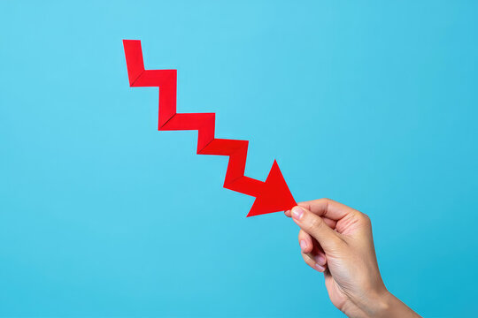 Downward Trend Arrow in Hand A Symbolic Representation of Decline and Loss Depicting Negative Performance and Decreasing Values in Business and Finance Against a Blue Backdrop