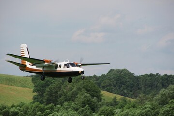 small twin-engine propeller plane coming in for a landing