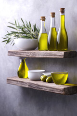 Bottles of olive oil and a bowl of olives sit on rustic wooden shelves with an olive branch in the background. Mediterranean cuisine and cooking ingredients