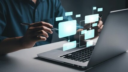 Person using laptop with flowchart overlay in a dark setting creating a business strategy plan - Powered by Adobe