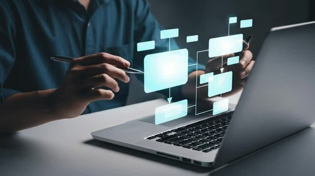 Person using laptop with flowchart overlay in a dark setting creating a business strategy plan