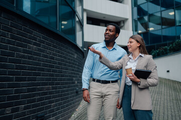 Businesspeople discussing a project while walking near office building