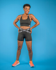 Fit African American Woman Posing in Studio Against Blue Background