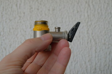 faucet for boiler heater device in man's hand on light background