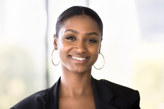 Beauty and charisma. Head shot portrait attractive smiling young African American businesswoman professional specialist expert looking at camera feel confident successful motivated in career and life