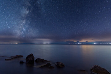 Beautiful night landscape , lake and stones  starry sky with Milky Way galaxy.