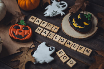 Happy Halloween Boo message spelled in wooden blocks with handmade gingerbread cookies, delicious...