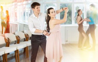 Young couples learning to dance latin american dances in a dance studio