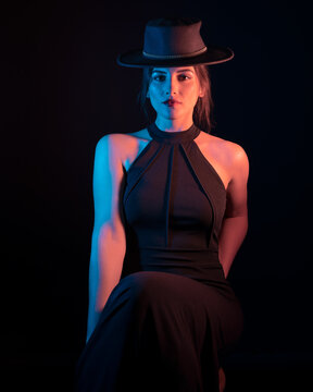Portrait of Woman Fashion Model wearing a black dress  in Color Gel Studio Lighting