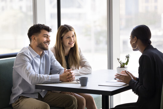 Consultation over coffee. Smiling married couple meeting with female professional tax consultant real estate broker insurer at cafe listen to expert advice with interest planning contract investment