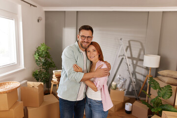 Couple celebrates their new home with smiles, hugging each other amid an inviting interior filled...