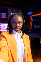 Content creator using smartphone to do live broadcast for subscribers, showing apartment studio,...