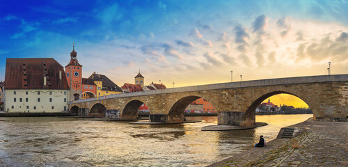 Sunset cityscape, panorama, banner - view of the Stone Bridge across the Danube in the Old Town of Regensburg, Bavaria, Germany