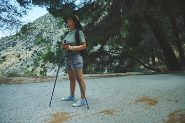 Woman Enjoying a Scenic Hike Through a Forest Trail in the Mountains