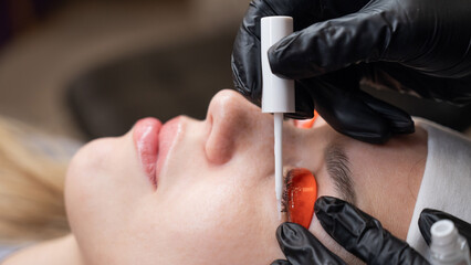 Caucasian woman undergoing eyelash lamination procedure. 
